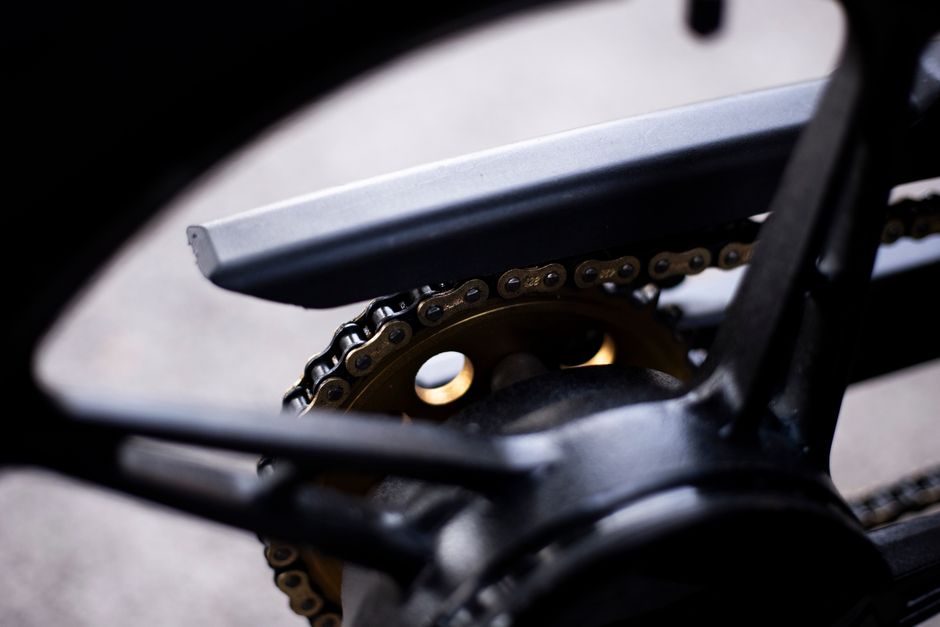 Moto sur béquille d'atelier pendant une révision des 20 000 km, outils et pièces visibles autour